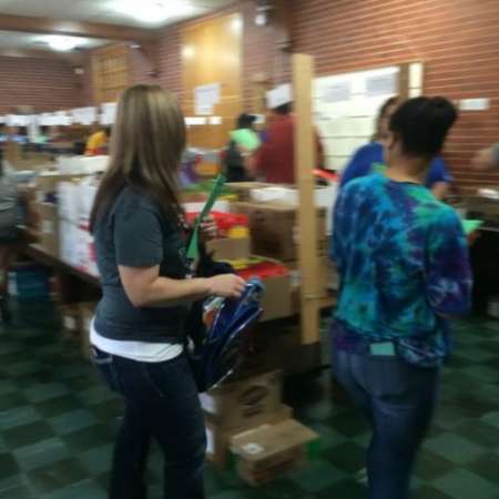 Volunteers fill backpacks with school supplies.